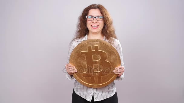 Glückliche Frau zeigt große Bitcoin-Münze. Konzept virtuellen Geldes. Kryptowährung — Stockvideo
