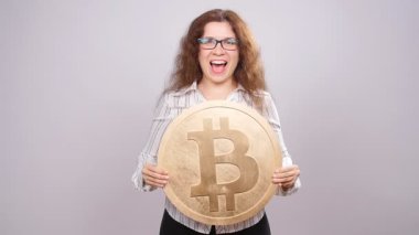 Mutlu kadın büyük Bitcoin para gösteriliyor. Sanal para kavramı. Cryptocurrency