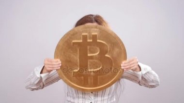 Mutlu kadın büyük Bitcoin para gösteriliyor. Sanal para kavramı. Cryptocurrency