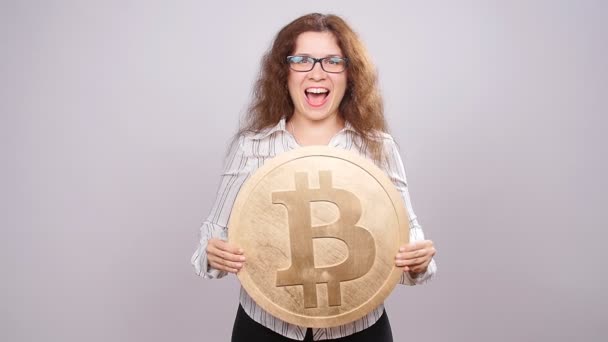 Щасливі жінка, показуючи big Bitcoin coin. Віртуальні гроші концепцію. Cryptocurrency — стокове відео