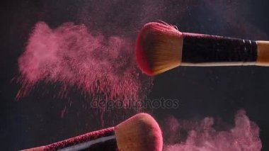 Karanlık bir arka plan üzerinde tozu ile iki makyaj fırçaları