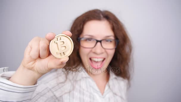 Mujer sosteniendo una moneda de oro Bitcoin — Vídeos de Stock