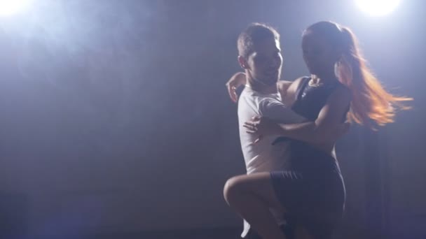 Young couple dance in a dark room with smoke — Stock Video