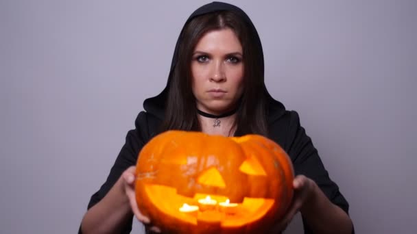 Witch with a carved pumpkin. Halloween concept — Stock Video