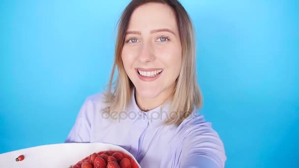 Young woman taking photo of herself with a bouquet of strawberries — Stock Video