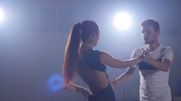 Молодая пара танцует бачату в помещении — стоковое видео