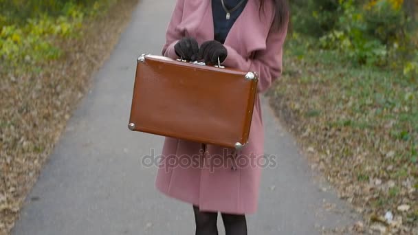 秋の公園でスーツケースを持つ若い女性 — ストック動画