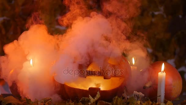 Хэллоуин тыква и свечи на листьях и дым — стоковое видео