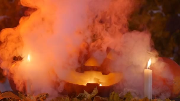 Citrouille d'Halloween et bougies sur les feuilles et la fumée — Video