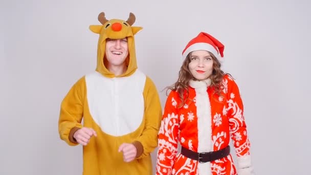 Mujer joven en sombrero de Santa Claus y hombre en traje de carnaval de ciervos. Diversión, vacaciones y Navidad — Vídeo de stock