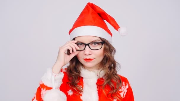 サンタ クロースの帽子とメガネを身に着けているかわいい女性 — ストック動画