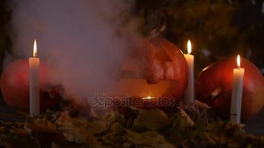 Cadılar Bayramı Balkabağı yüzünde ahşap arka plan ve sonbahar yaprakları