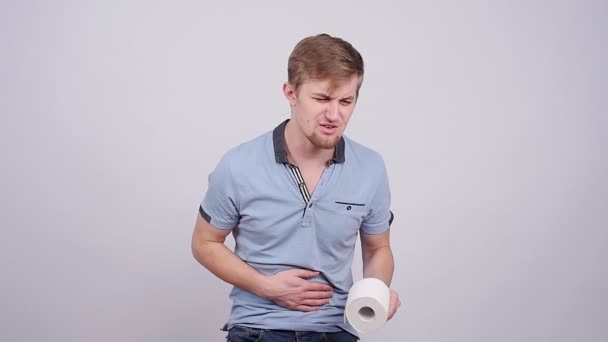 Homem com uma dor de estômago em um fundo cinza — Vídeo de Stock