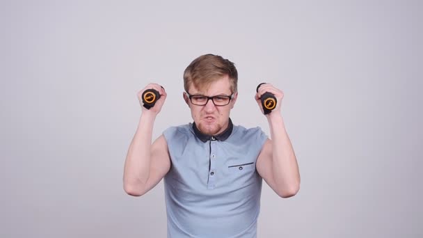 Funny sporty nerd in glasses and small dumbbells — Stock Video