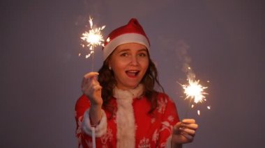 Şapkalı maytap tutan kırmızı Noel ve yeni yıl Noel Baba kadın