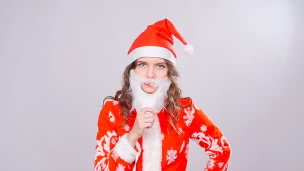 Funny chica de Navidad con rojo esponjoso Santa Sombrero y barba — Vídeos de Stock