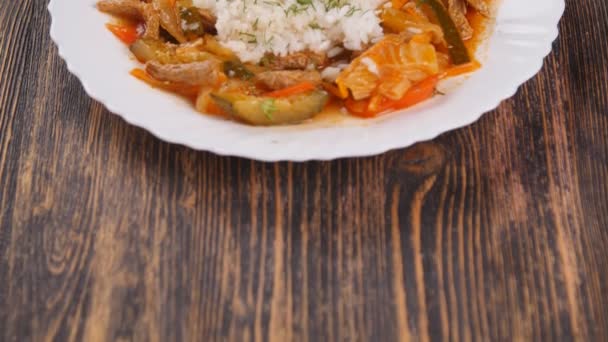 Reis mit Fleisch und Gemüse auf Holztisch — Stockvideo