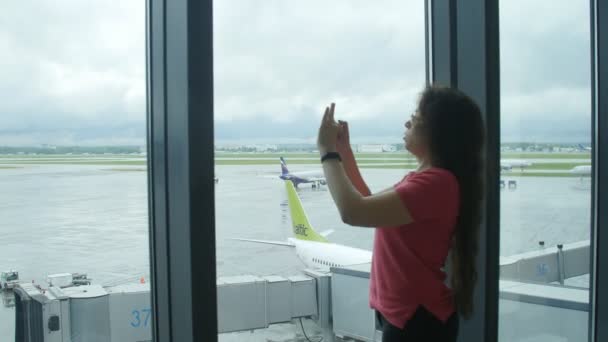 MOSCÚ, RUSIA - 25 DE MAYO DE 2017. Mujer joven tomando fotos en el teléfono celular en el aeropuerto — Vídeo de stock