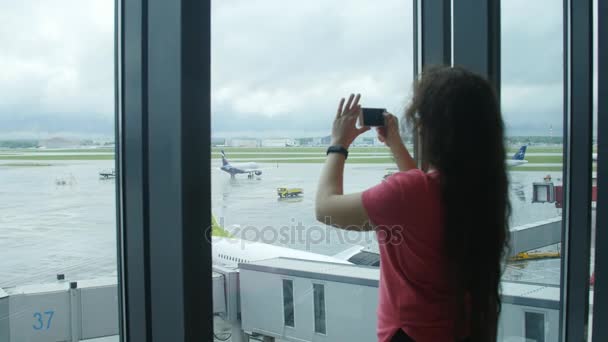 Moskou, Rusland - 25 mei 2017. Jonge vrouw nemen foto op mobiel op de luchthaven — Stockvideo