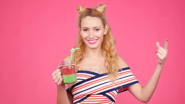 Mladá žena ruka drží smoothie koktejl růžové zdi — Stock video