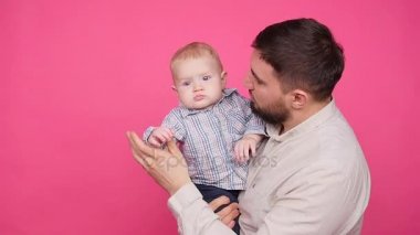 Pembe bir arka plan üzerinde şirin küçük oğluyla baba