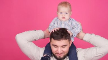 Pembe bir arka plan üzerinde şirin küçük oğluyla baba