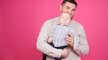 Pembe bir arka plan üzerinde şirin küçük oğluyla baba
