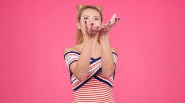 Bir ananas pembe bir arka plan üzerinde tutan genç kadın