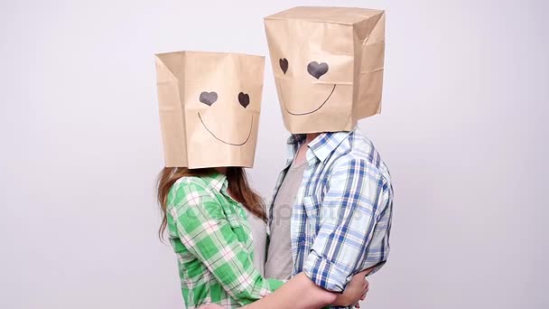 Pareja juntos hombre y mujer con bolsas sobre las cabezas sobre fondo gris — Vídeos de Stock