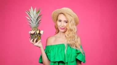 Kadın portre ve ananas pembe bir arka plan üzerinde güneş gözlüğü ile
