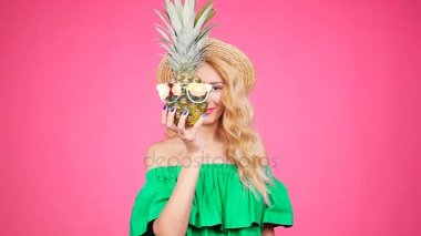Kadın portre ve ananas pembe bir arka plan üzerinde güneş gözlüğü ile