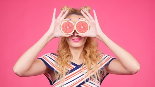 Happy young woman with two half of juicy grapefruit instead eyes — Stock Video