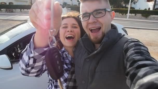 Happy couple showing the keys standing near the car — Stock Video