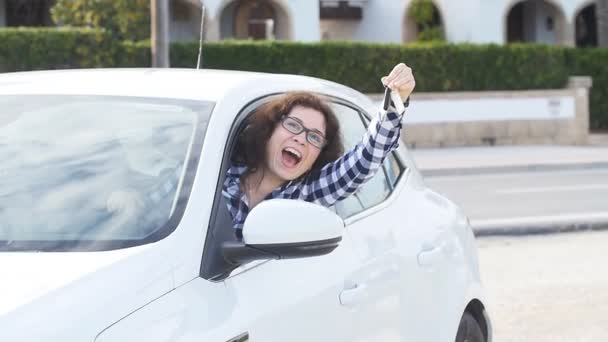 Щаслива жінка показує ключ нового автомобіля на відкритому повітрі — стокове відео