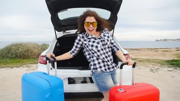 Ευτυχισμένη γυναίκα ταξιδιώτη με βαλίτσες κοντά στο αυτοκίνητό της — Αρχείο Βίντεο