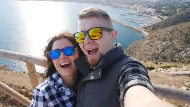 Jovem feliz casal amoroso levando selfie em montanhas perto do mar — Vídeo de Stock