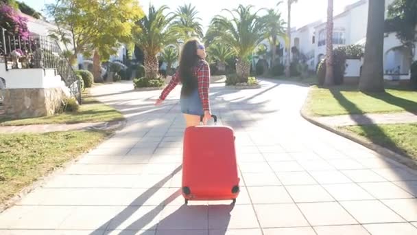 Счастливая женщина в отпуске бегает с чемоданом — стоковое видео