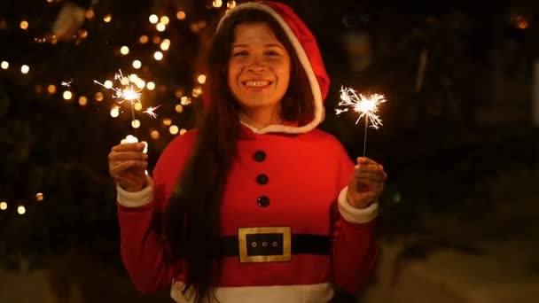 Молода Санта Клаус жінка тримає іскриста і бенгальський вогонь — стокове відео