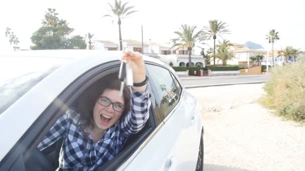 Молодая счастливая белая женщина показывает ключ от нового автомобиля — стоковое видео