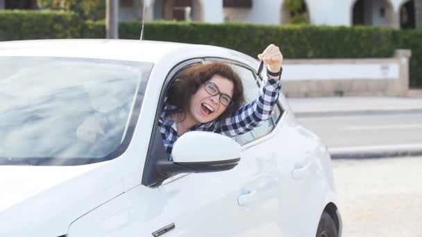 Молода щаслива біла жінка показує ключ нового автомобіля — стокове відео