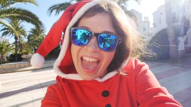 Boże Narodzenie i ludzi pojęcie - szczęśliwa młoda dziewczyna w kapeluszu zimą w pobliżu drzewa, zabawy na świeżym powietrzu — Wideo stockowe
