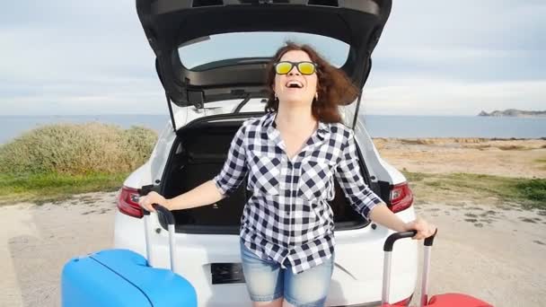 Glad ung kvinna på sommaren resa semester sitter i en bil stam — Stockvideo