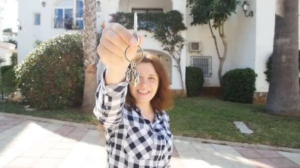 Mujer joven feliz en frente de un nuevo hogar con llaves — Vídeos de Stock