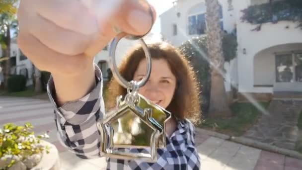 Mujer joven feliz en frente de un nuevo hogar con llaves — Vídeos de Stock