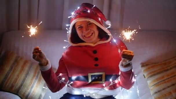 Joyeux jeune femme en costume de Père Noël avec des lumières du Bengale — Video