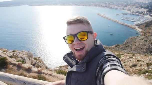 Hombre feliz excursionista foto autofoto turística en la montaña cerca del mar — Vídeo de stock