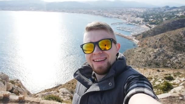 Hombre feliz excursionista foto autofoto turística en la montaña cerca del mar — Vídeo de stock
