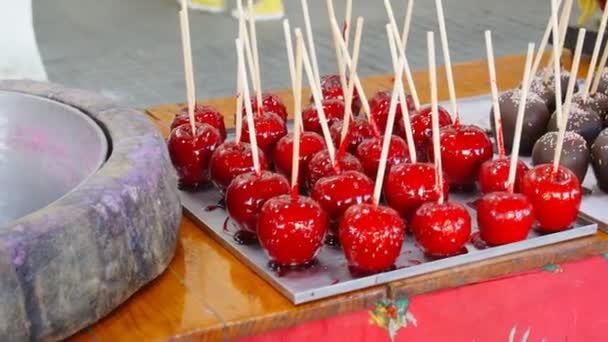 Maçãs de caramelo em chocolate e nozes. Comida de rua — Vídeo de Stock