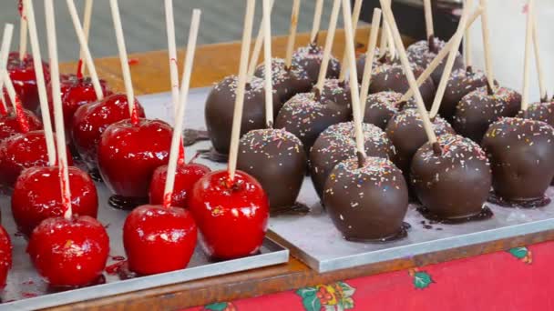 Manzanas de caramelo en chocolate y nueces. Comida callejera — Vídeos de Stock