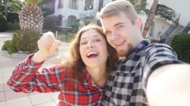 Yeni ev kendi evin anahtarları gösterilen önünde Çift